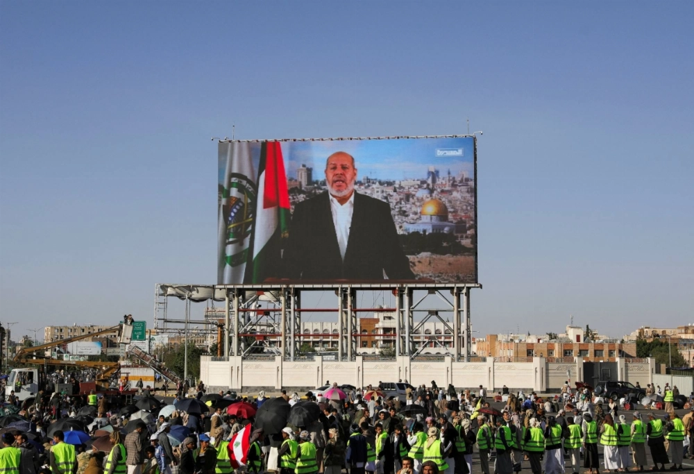 Protesters, mainly Houthi supporters, stand near a screen displaying senior Hamas official Khalil al-Hayya during a rally to show support for Hezbollah and Palestinians in the Gaza Strip, in Sanaa, Yemen, on Friday. Protesters, mainly Houthi supporters, stand near a screen displaying senior Hamas official Khalil al-Hayya during a rally to show support for Hezbollah and Palestinians in the Gaza Strip, in Sanaa, Yemen, on Friday.