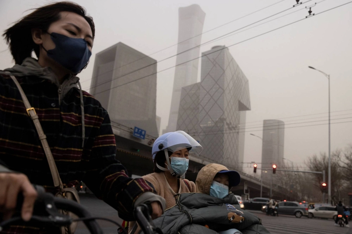 People wear face masks on a day with a high level of pollution in Beijing in March of last year.  People wear face masks on a day with a high level of pollution in Beijing in March of last year.