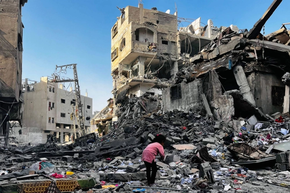 A Palestinian girl looks through the rubble of a building after an Israeli strike in Beit Lahia, in the northern Gaza Strip, on Tuesday. A Palestinian girl looks through the rubble of a building after an Israeli strike in Beit Lahia, in the northern Gaza Strip, on Tuesday.