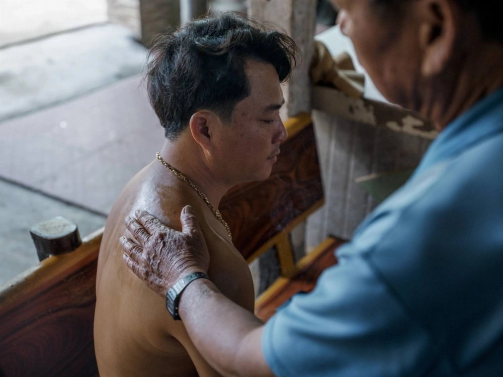 Nguyen Thanh Bien gets a massage with medicated oil from his father to help with injuries from being beaten by the Chinese authorities while fishing in the South China Sea, in Quang Ngai, Vietnam, on Oct. 18. Nguyen Thanh Bien gets a massage with medicated oil from his father to help with injuries from being beaten by the Chinese authorities while fishing in the South China Sea, in Quang Ngai, Vietnam, on Oct. 18.