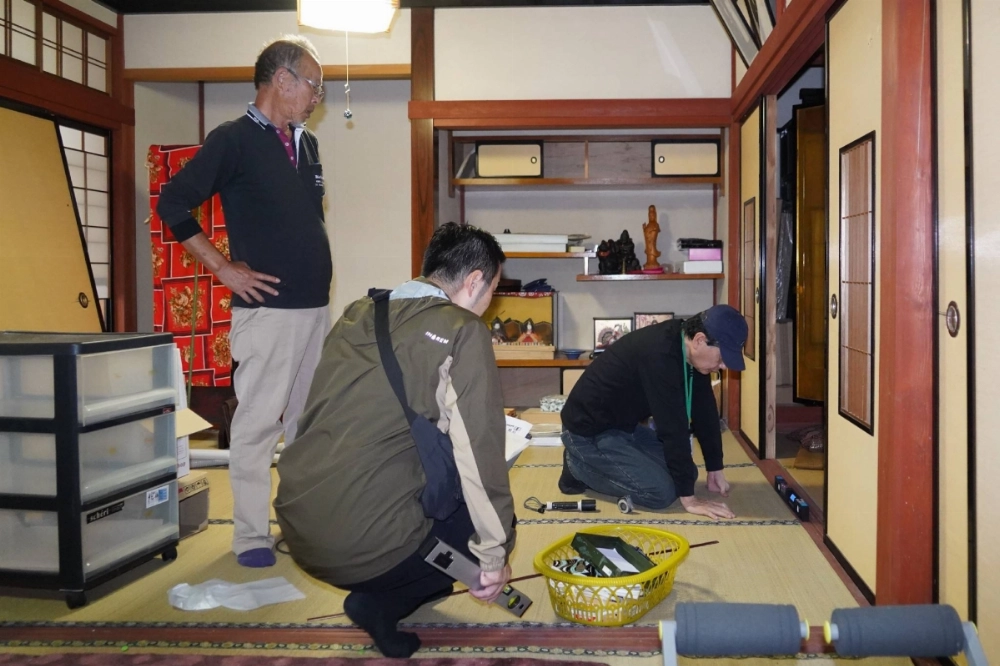 Masaaki Iene (left) watches as an architect from a local support center checks the level of damage at his house in Suzu, Ishikawa Prefecture, on Oct. 15 to see whether previous assessments carried out by local government officials were appropriate. Masaaki Iene (left) watches as an architect from a local support center checks the level of damage at his house in Suzu, Ishikawa Prefecture, on Oct. 15 to see whether previous assessments carried out by local government officials were appropriate.
