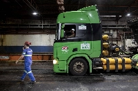 Workers prepare to unload a truck powered by biomethane fuel in the Copersucar SA sugar terminal at the Port of Santos in Santos, Brazil, on Oct. 25. | Bloomberg