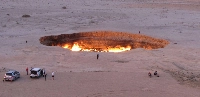 A photo taken on May 3, 2014, shows people visiting the Gates of Hell, a huge burning gas crater in the heart of Turkmenistan's Karakum desert. Turkmenistan said on Oct. 25 that it will capture the gas fueling the area, putting the human-made fire pit at risk of closure as the reclusive state seeks to reduce its greenhouse emissions. | AFP-JIJI