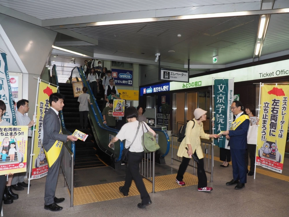 Saitama Gov. Motohiro Ono (right) and others call on users to stand still on the escalator in the city of Saitama in September. Saitama Gov. Motohiro Ono (right) and others call on users to stand still on the escalator in the city of Saitama in September.