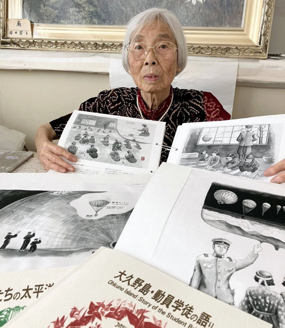 Reiko Okada shows her ink paintings that depict female students making paper balloons as she talks about her wartime experience on Okunoshima island in Hiroshima Prefecture. Reiko Okada shows her ink paintings that depict female students making paper balloons as she talks about her wartime experience on Okunoshima island in Hiroshima Prefecture.