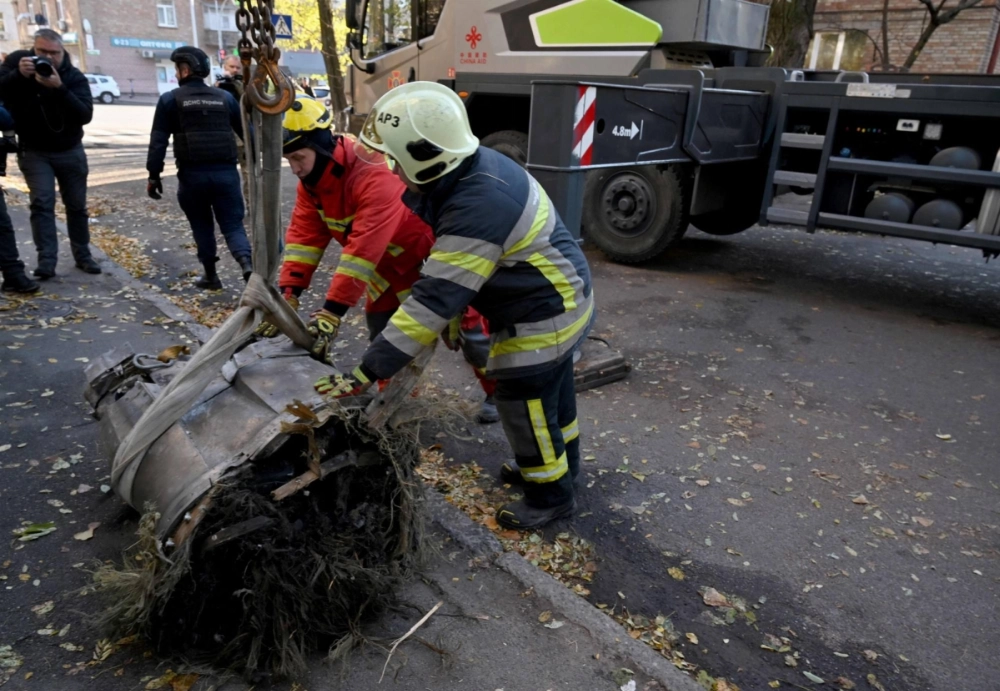 Ukrainian emergency service personnel remove fragments of a downed Russian hypersonic missile which hit a five-story residential building in Kyiv on Sunday. 
  Ukrainian emergency service personnel remove fragments of a downed Russian hypersonic missile which hit a five-story residential building in Kyiv on Sunday.