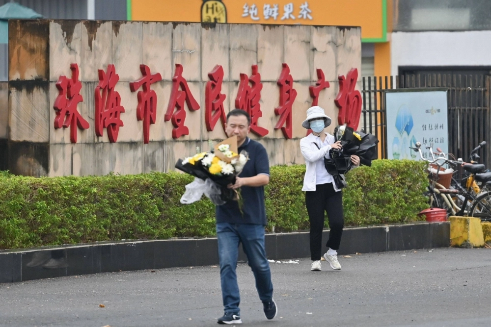 Workers remove flowers from a makeshift memorial outside the Zhuhai Sports Center in Zhuhai in south China's Guangdong province on Nov. 13, two days after 35 people were killed in one of the country's deadliest car attacks in years.  Workers remove flowers from a makeshift memorial outside the Zhuhai Sports Center in Zhuhai in south China's Guangdong province on Nov. 13, two days after 35 people were killed in one of the country's deadliest car attacks in years.