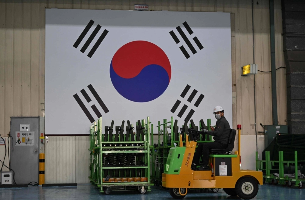 A South Korean engineer drives past a South Korean flag at the Hanwha Aerospace factory in Changwon on Thursday. A South Korean engineer drives past a South Korean flag at the Hanwha Aerospace factory in Changwon on Thursday.