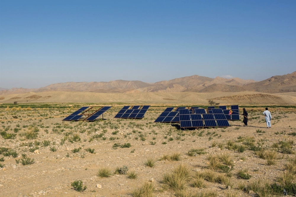 A farmer cleans solar panels in a field in the Baluchistan region of Pakistan. A farmer cleans solar panels in a field in the Baluchistan region of Pakistan.