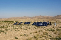 A farmer cleans solar panels in a field in the Baluchistan region of Pakistan. | Bloomberg