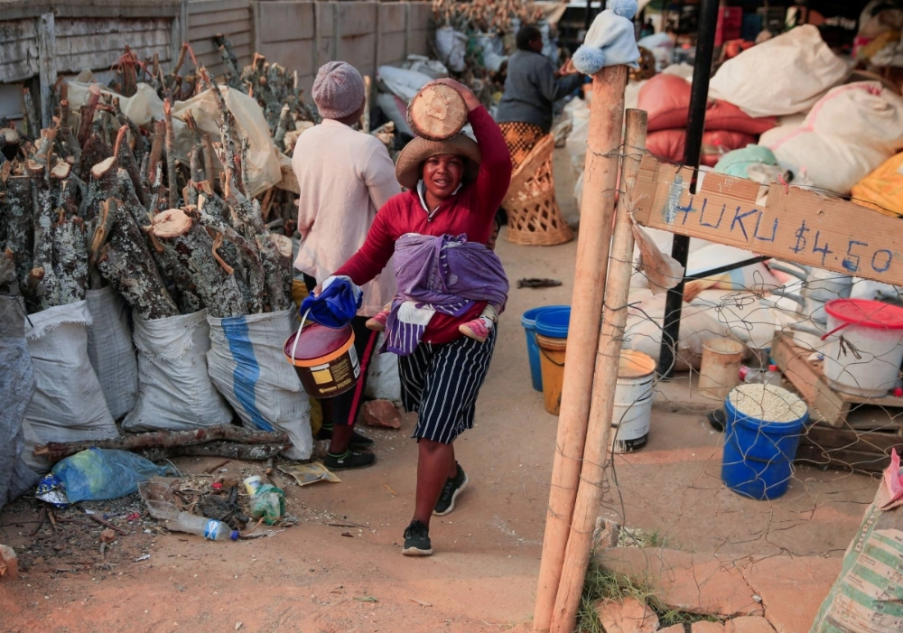 A woman carries firewood she bought at a marketplace in Harare, Zimbabwe, on Oct. 2. Telehealth — the use of technology to provide and access health care services remotely — has been growing around the world but is relatively new in Zimbabwe. A woman carries firewood she bought at a marketplace in Harare, Zimbabwe, on Oct. 2. Telehealth — the use of technology to provide and access health care services remotely — has been growing around the world but is relatively new in Zimbabwe.