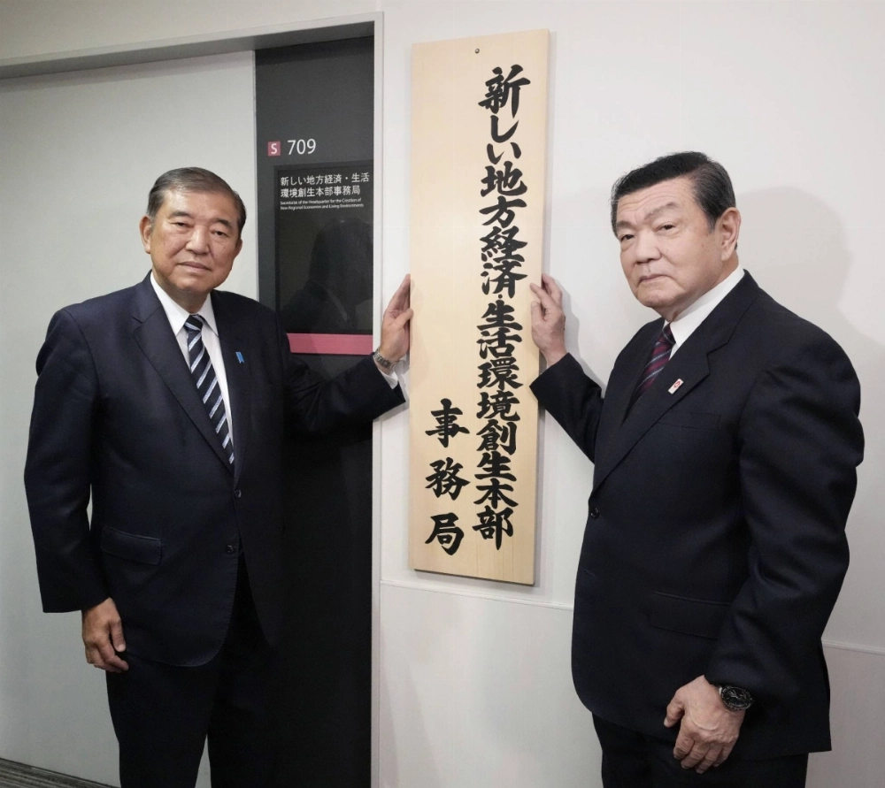 Yoshitaka Ito, minister for regional revitalization (right), and Prime Minister Shigeru Ishiba set up a signboard for an office in charge of regional revitalization on Nov. 8 in Tokyo. Yoshitaka Ito, minister for regional revitalization (right), and Prime Minister Shigeru Ishiba set up a signboard for an office in charge of regional revitalization on Nov. 8 in Tokyo.