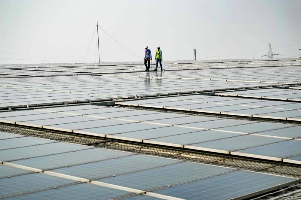 Employees at SunSource Energy inspect solar panels installed at a food processing plant in Greater Noida, India, on Nov. 21.  Employees at SunSource Energy inspect solar panels installed at a food processing plant in Greater Noida, India, on Nov. 21.