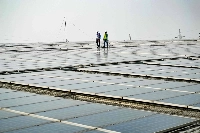 Employees at SunSource Energy inspect solar panels installed at a food processing plant in Greater Noida, India, on Nov. 21.  | AFP-JIJI