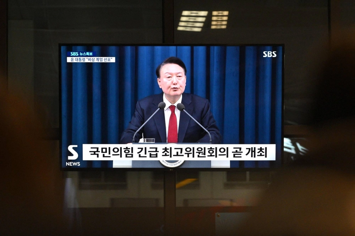 South Korea's President Yoon Suk Yeol is seen speaking on a television in a train station in Seoul late Tuesday evening. During the broadcast, he declared emergency martial law, saying the step was necessary to protect the country from South Korea's President Yoon Suk Yeol is seen speaking on a television in a train station in Seoul late Tuesday evening. During the broadcast, he declared emergency martial law, saying the step was necessary to protect the country from
