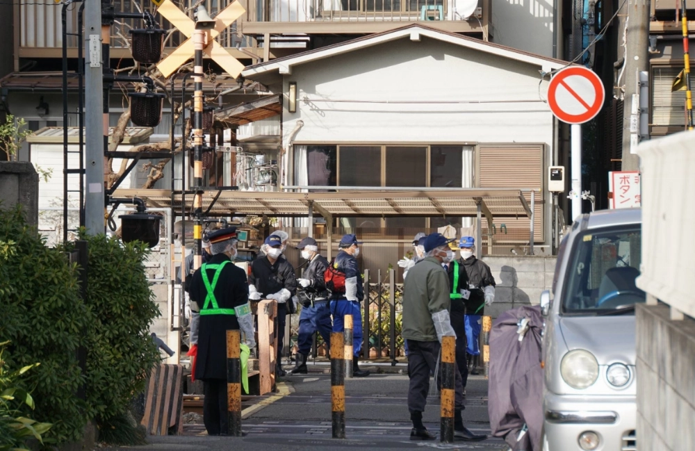 Police officers reinvestigate a Tobu Tojo Line railroad crossing in Tokyo's Itabashi Ward on Dec. 27, 2023, after a man was fatally hit by a train weeks earlier. Police officers reinvestigate a Tobu Tojo Line railroad crossing in Tokyo's Itabashi Ward on Dec. 27, 2023, after a man was fatally hit by a train weeks earlier.