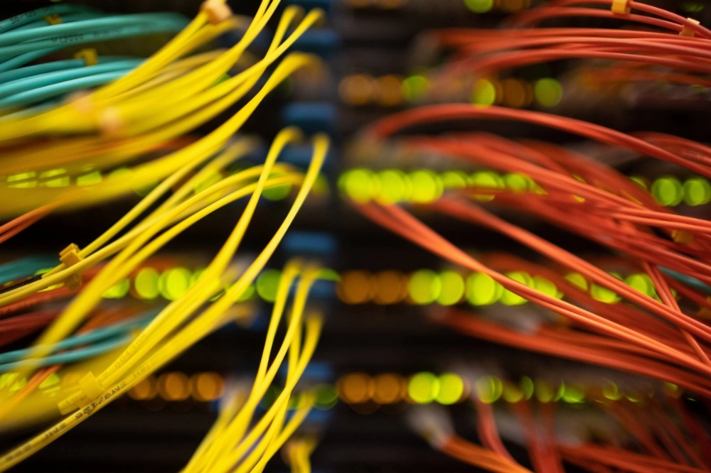 Cables connect to servers at a data center. The rapid global adoption of AI has triggered a boom in demand for the energy-hungry data centers on which the technology depends, putting power grids to the test.  Cables connect to servers at a data center. The rapid global adoption of AI has triggered a boom in demand for the energy-hungry data centers on which the technology depends, putting power grids to the test.
