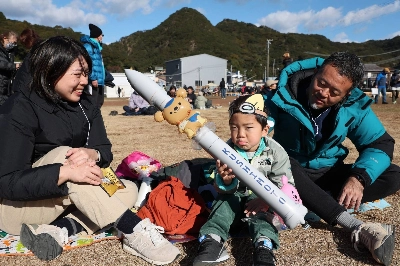 A boy who came to watch the launch of Space One's Kairos rocket in Nachikatsuura, Wakayama Prefecture, on Sunday shows his disappointment after the liftoff was postponed again. A boy who came to watch the launch of Space One's Kairos rocket in Nachikatsuura, Wakayama Prefecture, on Sunday shows his disappointment after the liftoff was postponed again.