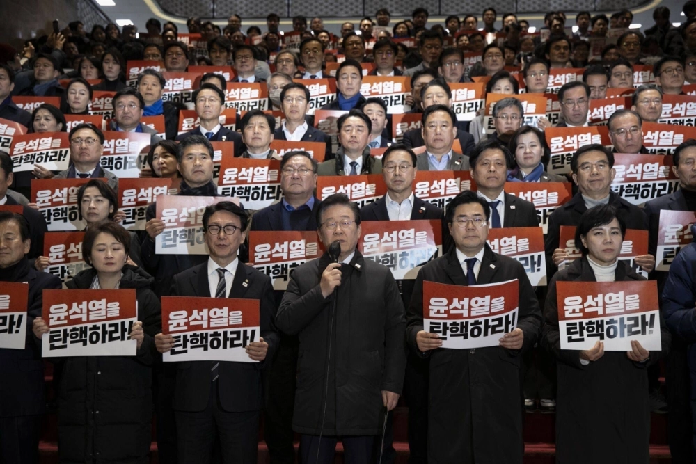 Lee Jae-myung, leader of South Korea's Democratic Party, speaks to members of the media on the steps inside the National Assembly after an impeachment vote against South Korean President Yoon Suk Yeol in Seoul on Dec. 7. Lee Jae-myung, leader of South Korea's Democratic Party, speaks to members of the media on the steps inside the National Assembly after an impeachment vote against South Korean President Yoon Suk Yeol in Seoul on Dec. 7.