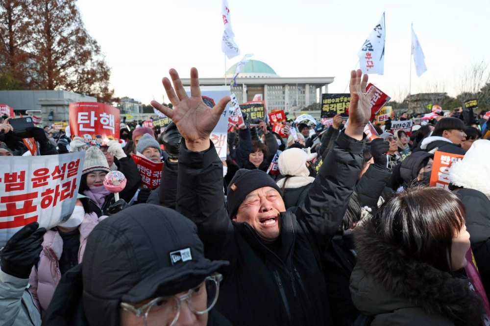 A demonstrator reacts after lawmakers passed a motion to impeach South Korean President Yoon Suk Yeol on Saturday. A demonstrator reacts after lawmakers passed a motion to impeach South Korean President Yoon Suk Yeol on Saturday.