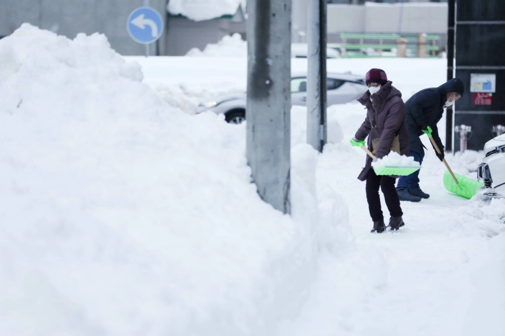 People remove snow from a sidewalk in Sapporo after a heavy snowstorm in January 2022. A team of Japanese scientists has concluded that global warming was what caused Hokkaido to receive up to 20% more snow than usual in December 2021. People remove snow from a sidewalk in Sapporo after a heavy snowstorm in January 2022. A team of Japanese scientists has concluded that global warming was what caused Hokkaido to receive up to 20% more snow than usual in December 2021.