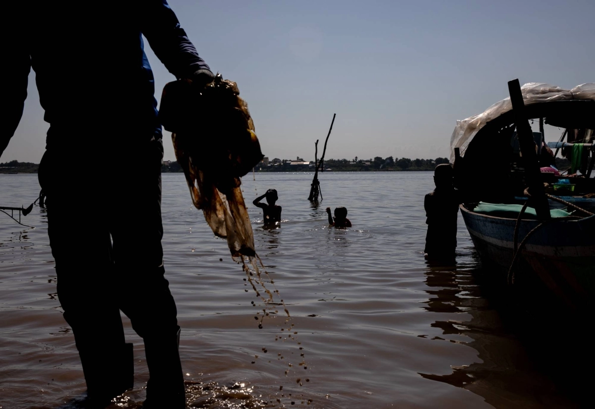 Children swim at the confluence of the Mekong and Tonle Sap rivers in Phnom Penh as workers clear the banks of plastic waste. Children swim at the confluence of the Mekong and Tonle Sap rivers in Phnom Penh as workers clear the banks of plastic waste.