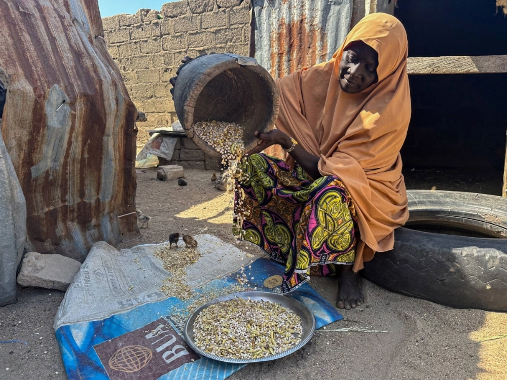 A woman who was displaced by a flood shells cowpeas as she sits outside her shelter in Banki, in Maiduguri, Nigeria, in October. A woman who was displaced by a flood shells cowpeas as she sits outside her shelter in Banki, in Maiduguri, Nigeria, in October.