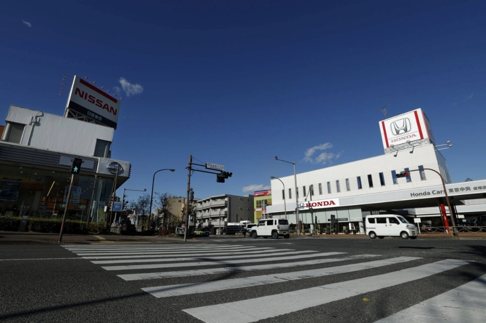 A Nissan dealership and a Honda dealership in Tokyo. As the two firms negotiation a potential merger, Nomura Holdings is advising Honda, while Nissan has retained Mizuho Financial Group and Bank of America.  A Nissan dealership and a Honda dealership in Tokyo. As the two firms negotiation a potential merger, Nomura Holdings is advising Honda, while Nissan has retained Mizuho Financial Group and Bank of America.