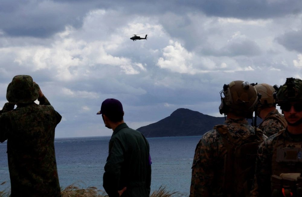 A Ground Self-Defense Force helicopter flies over GSDF's Amphibious Rapid Deployment Brigade soldiers and U.S. Marines during a drill in Okinawa last year.  A Ground Self-Defense Force helicopter flies over GSDF's Amphibious Rapid Deployment Brigade soldiers and U.S. Marines during a drill in Okinawa last year.