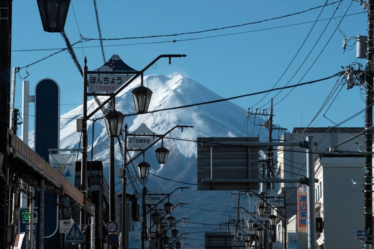 A view of Mount Fuji from a shopping street in Fujiyoshida, Yamanashi Prefecture. The first snowcap of 2024 on Mount Fuji was delayed about a month amid record-setting temperatures in Japan throughout much of the year.   A view of Mount Fuji from a shopping street in Fujiyoshida, Yamanashi Prefecture. The first snowcap of 2024 on Mount Fuji was delayed about a month amid record-setting temperatures in Japan throughout much of the year.