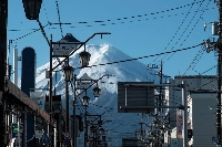 A view of Mount Fuji from a shopping street in Fujiyoshida, Yamanashi Prefecture. The first snowcap of 2024 on Mount Fuji was delayed about a month amid record-setting temperatures in Japan throughout much of the year.   | Bloomberg