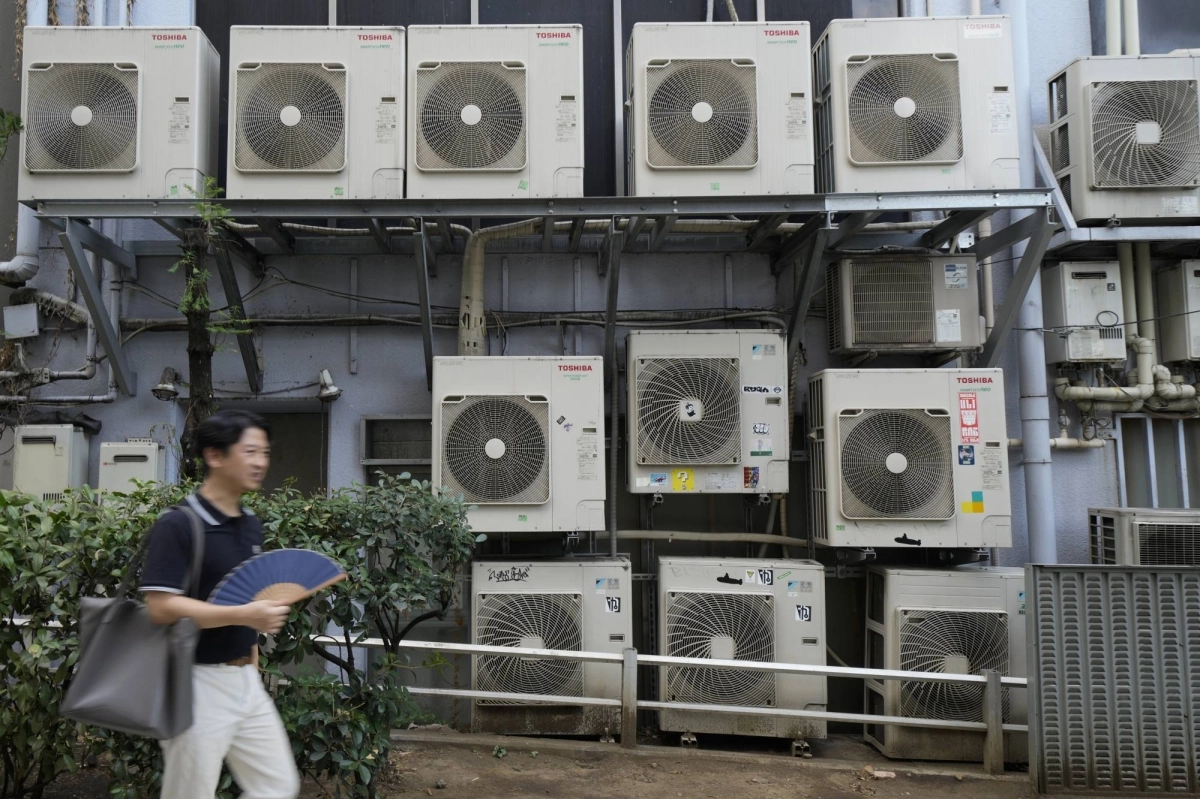 A pedestrian walks past air conditioning units in Tokyo in July. Air conditioners sold well in 2024 and even into the autumn season as high temperatures persisted.  A pedestrian walks past air conditioning units in Tokyo in July. Air conditioners sold well in 2024 and even into the autumn season as high temperatures persisted.