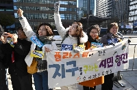 South Korean environmental activists hold a banner reading "Citizen's march to save the planet from plastic" during a campaign to reduce plastic use in Seoul on Dec. 3. | AFP-JIJI