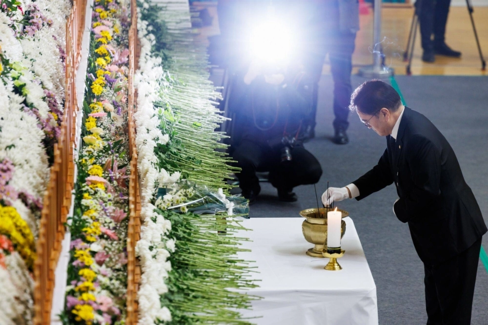 National Assembly Speaker Woo Won-shik offers joss sticks at a memorial for the victims of the Jeju Air crash in Muan, South Korea, on Monday. National Assembly Speaker Woo Won-shik offers joss sticks at a memorial for the victims of the Jeju Air crash in Muan, South Korea, on Monday.