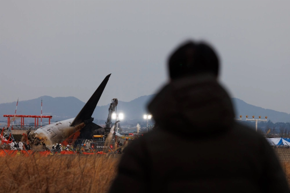 The tail of Jeju Air Flight 2216 is seen at Muan International Airport in Muan County, South Korea, on Sunday after the aircraft careered down the runway with no landing gear deployed and smashed into a concrete wall, killing all but two of the 181 people on board. The tail of Jeju Air Flight 2216 is seen at Muan International Airport in Muan County, South Korea, on Sunday after the aircraft careered down the runway with no landing gear deployed and smashed into a concrete wall, killing all but two of the 181 people on board.