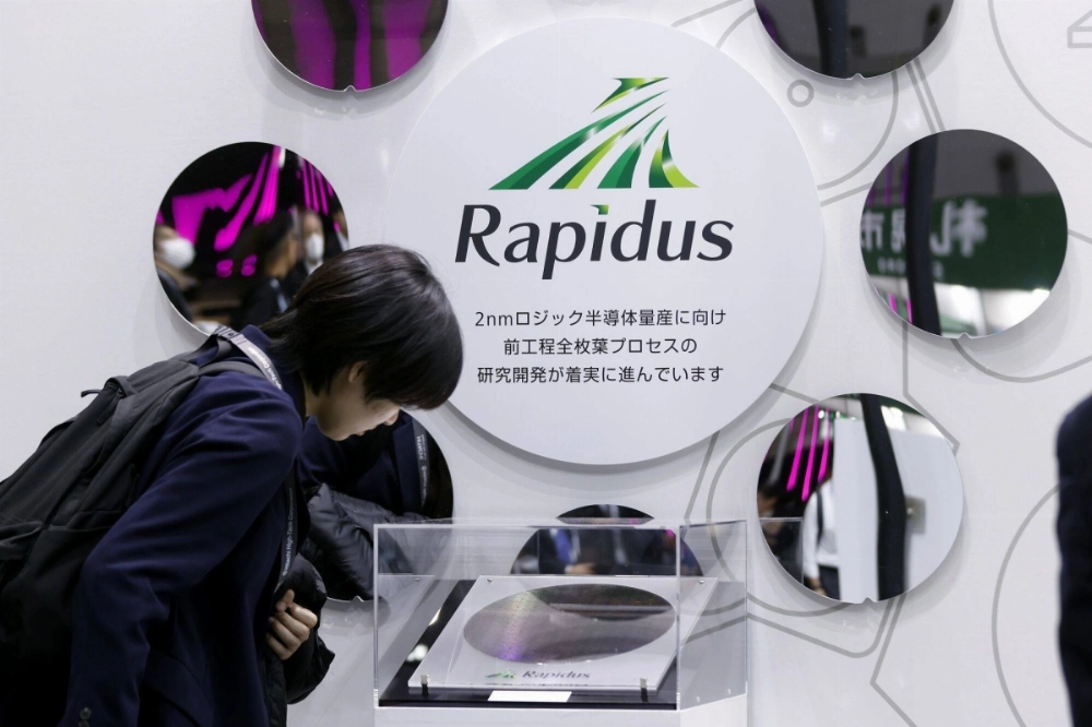 An attendee looks at a prototype of a 2-nanometer gate-all-around wafer produced by Rapidus and International Business Machines Corp. at the Semicon Japan exhibition in Tokyo in December. An attendee looks at a prototype of a 2-nanometer gate-all-around wafer produced by Rapidus and International Business Machines Corp. at the Semicon Japan exhibition in Tokyo in December.