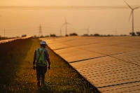 A maintenance worker inspects solar panels at a power plant in southern India.  | Bloomberg