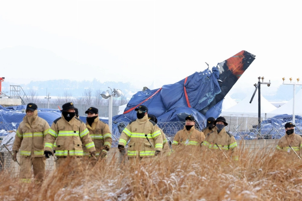 Firefighters take part in an operation near the site where a Jeju Air plane crashed and burst into flames, at Muan International Airport in South Korea on Saturday.  Firefighters take part in an operation near the site where a Jeju Air plane crashed and burst into flames, at Muan International Airport in South Korea on Saturday.
