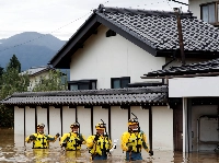 Rescue workers search a flooded area during the aftermath of Typhoon Hagibis, which caused severe floods at the Chikuma River, in the city of Nagano in October 2019. | REUTERS