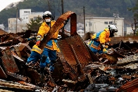 Policemen search for victims in Wajima, Ishikawa Prefecture, in January 2024 following a powerful quake on New Year's Day.  | REUTERS