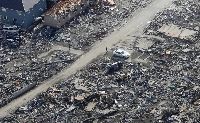 People walk in an area damaged by the March 11, 2011, earthquake and tsunami, near Sendai in April 2011. | Reuters