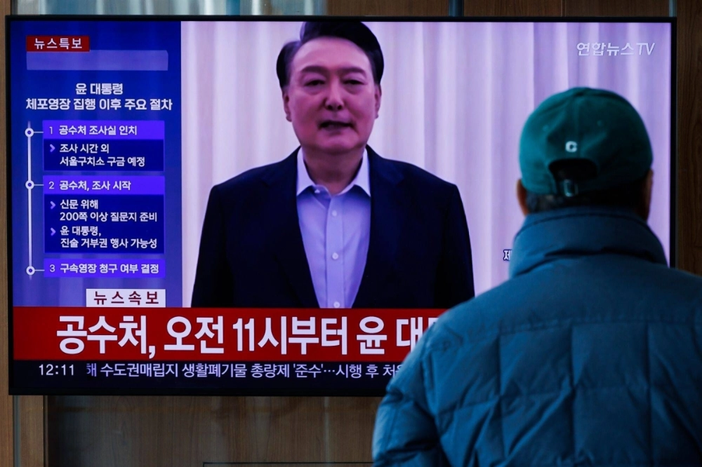A screen displays a news report on the arrest of South Korean President Yoon Suk Yeol in Seoul on Wednesday. Investigators arrested Yoon after launching a pre-dawn operation to bring the impeached leader in for questioning over his short-lived martial law declaration.  A screen displays a news report on the arrest of South Korean President Yoon Suk Yeol in Seoul on Wednesday. Investigators arrested Yoon after launching a pre-dawn operation to bring the impeached leader in for questioning over his short-lived martial law declaration.