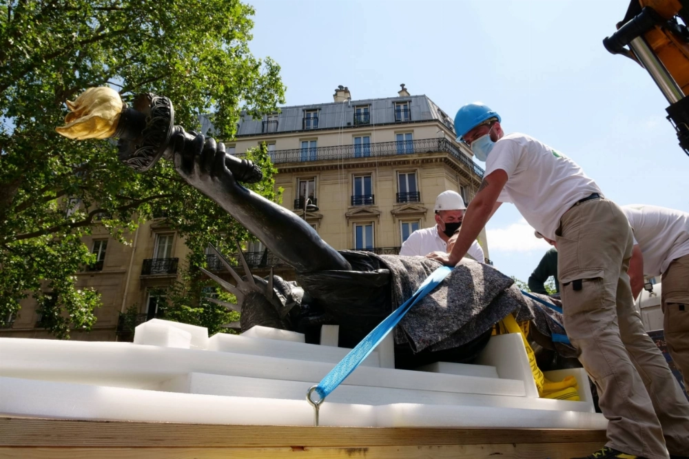 French workers load a replica of the Statue of Liberty, or Lady Liberty, onto a truck outside the Musee des Arts et Metiers in Paris in June 2021, before it departs for Ellis Island in New York to arrive on Independence Day. French workers load a replica of the Statue of Liberty, or Lady Liberty, onto a truck outside the Musee des Arts et Metiers in Paris in June 2021, before it departs for Ellis Island in New York to arrive on Independence Day.