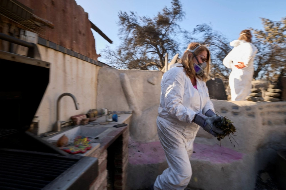 Marialyce Pedersen cleans burned leaves and debris that accumulated in the sink of her outdoor kitchen made of cob that survived the Eaton fire when her home burned in Altadena, California, on Jan. 20. Marialyce Pedersen cleans burned leaves and debris that accumulated in the sink of her outdoor kitchen made of cob that survived the Eaton fire when her home burned in Altadena, California, on Jan. 20.