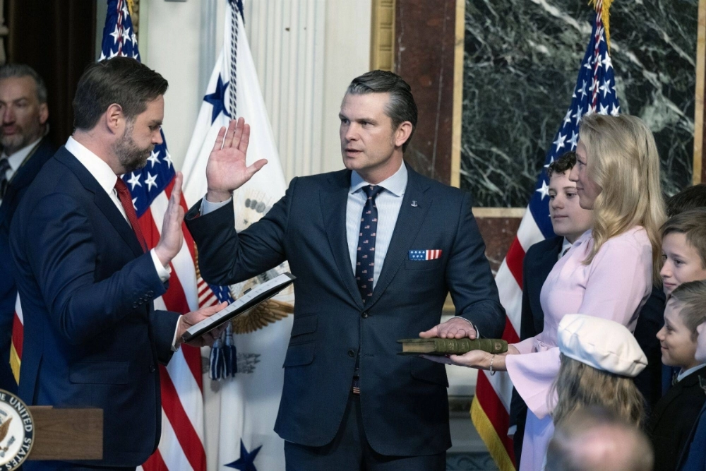 U.S. Vice President JD Vance (left) swears in Pete Hegseth (center) as U.S. secretary of defense during a ceremony in Washington on Saturday.  U.S. Vice President JD Vance (left) swears in Pete Hegseth (center) as U.S. secretary of defense during a ceremony in Washington on Saturday.