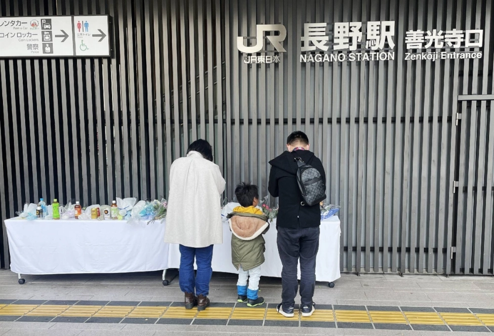 People pray for the victims of a deadly stabbing attack outside Nagano Station, on Sunday. People pray for the victims of a deadly stabbing attack outside Nagano Station, on Sunday.