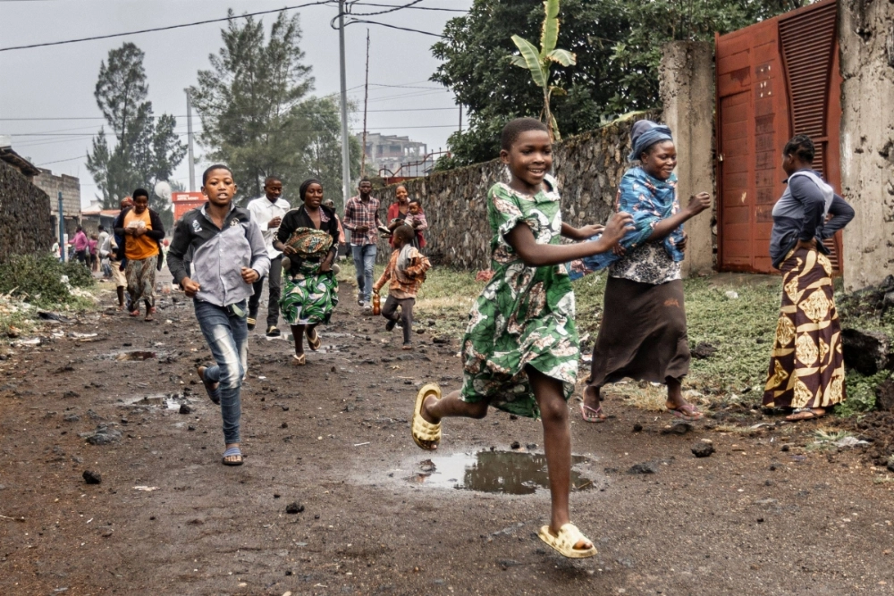Residents run away after seeing members of the M23 armed group walking through a street of the besieged Congolese city of Goma on Monday. Residents run away after seeing members of the M23 armed group walking through a street of the besieged Congolese city of Goma on Monday.