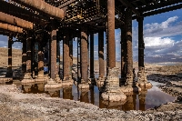 Calcified salt formations at the base of pillars holding a disabled pumping station from the northern basin of the Dead Sea near Kibbutz Ein Gedi on Dec. 30, after the station stopped operations due to the lake's drying | AFP-JIJI