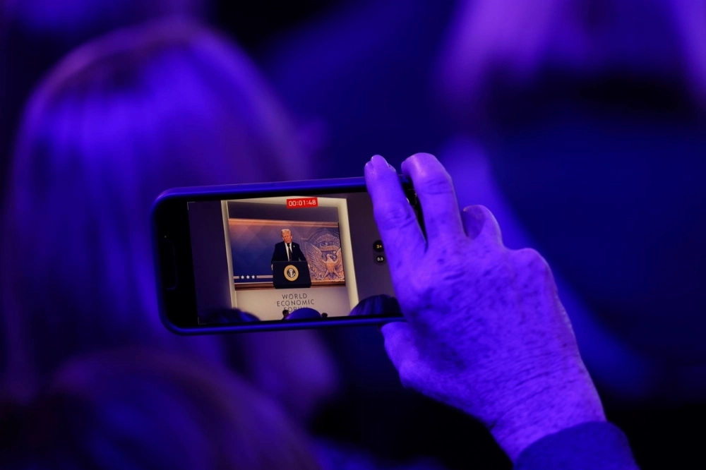 An attendee records a virtual address by U.S. President Donald Trump at the World Economic Forum (WEF) in Davos, Switzerland, on Jan. 23. An attendee records a virtual address by U.S. President Donald Trump at the World Economic Forum (WEF) in Davos, Switzerland, on Jan. 23.