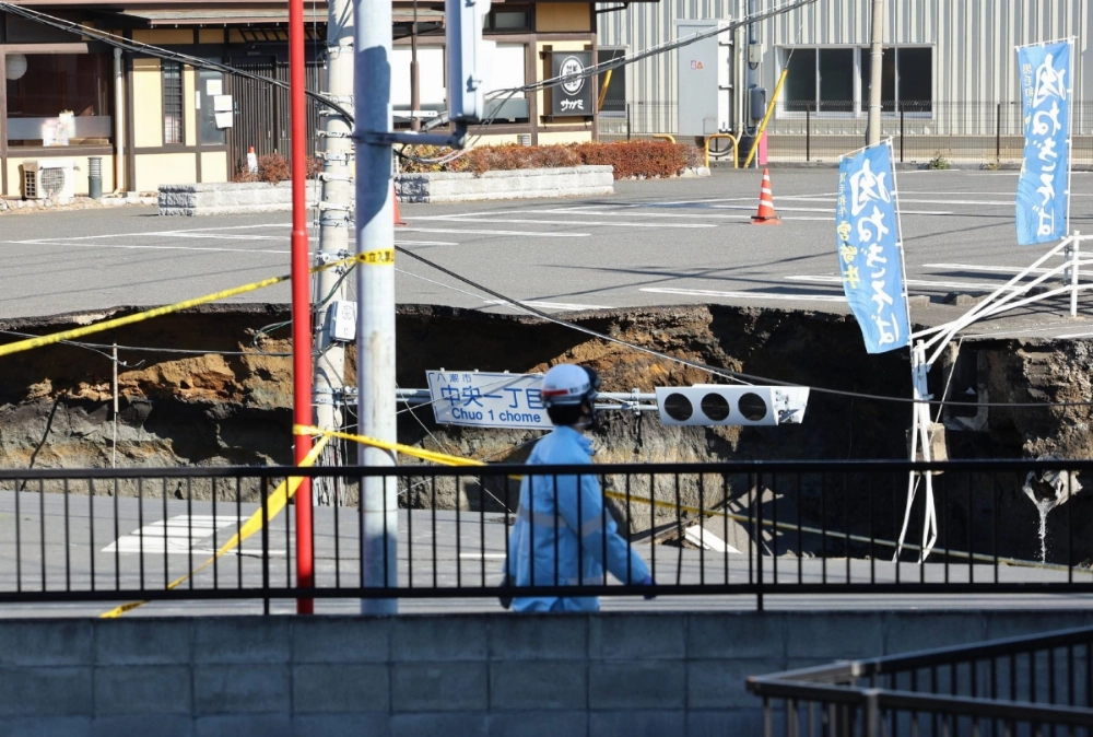 A sinkhole at an intersection on a road in the city of Yashio, Saitama Prefecture, on Thursday morning A sinkhole at an intersection on a road in the city of Yashio, Saitama Prefecture, on Thursday morning